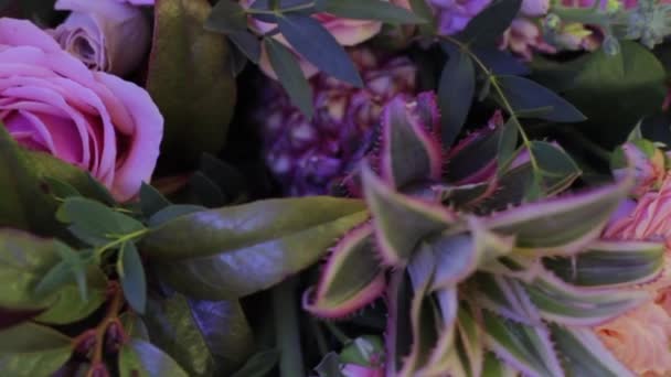Μεγάλη περιστρεφόμενη μπουκέτο τριαντάφυλλα με ανανά σε πολύχρωμα φως — Αρχείο Βίντεο