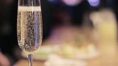 Bulanık arka planda bir kadeh şampanya.