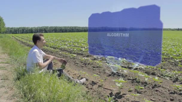 Man is working on HUD holographic display with text Algorithm on the edge of the field — Stock Video