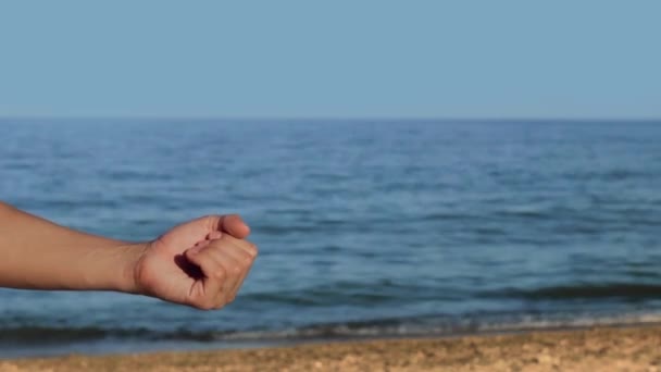 Руки на пляже держат текст на граммах — стоковое видео