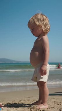 Güzel, sıcak bir günde, kaygısız bir çocuk kıyıları keşfeder, nazik dalgaların yanında durur, doğanın çarpıcı güzelliği arasında saf masumiyeti yakalar.