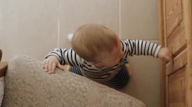 Sevimli ve oyuncu çocuk, merak dolu, kapıyı açmaya hevesle uzanıyor, sıcak, rahat bir ev ortamında keşif ve masumiyet ruhunu mükemmel bir şekilde somutlaştırıyor.