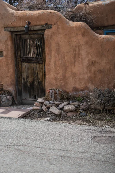 Adobe Wall 'da yıpranmış ahşap kapı