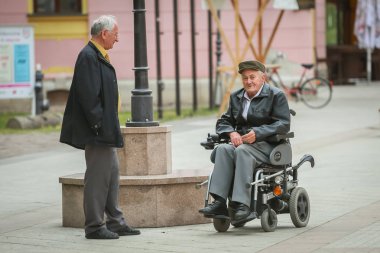 Hayır, Hırvatistan - 14 Mayıs 2018: bir tekerlekli sandalye ve Hayır, Hırvatistan sokakta sürüş sırasında iki erkekler yakın çekim.