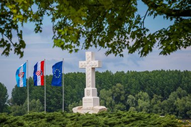 Savaş mağdurlarına ücretsiz Hırvat Savaşı savunucuları bellekte yanında Vukovar, Hırvatistan'da çekilen bayraklar ile Hırvatistan diyor çapraz anıt bir görünümünü.