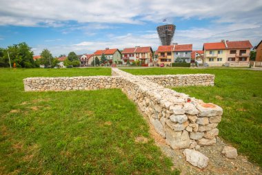 Adak taş haç sembolü kurban ve arka planda Vukovar, Hırvatistan Vukovar su kulesinde ile Kurtuluş Savaşı sırasında şehrin acı olarak bir görünüm.