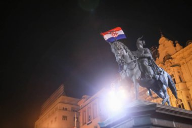 Zagreb, Hırvatistan - 7 Temmuz 2018: Hırvat futbol taraftarları Zagrep, Hırvatistan için Ban Jelacic meydanında Hırvat milli takımının kazanmak sonra Ban Josip Jelacic heykeli Hırvat bayrak bayrak.
