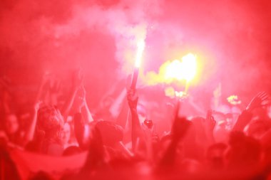 Futbol taraftarları meşaleler yakarak zaferini kutluyor.