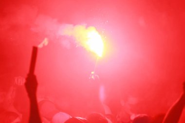 Futbol taraftarları meşaleler yakarak zaferini kutluyor.