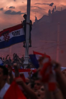 Zagreb, Hırvatistan - Temmuz 16,2018: Milli hoş geldiniz ev kutlama. Hırvat futbol taraftarları üstüne günbatımı ve kalabalık Ban Jelacic kare üzerinde bayrak ile binasında.