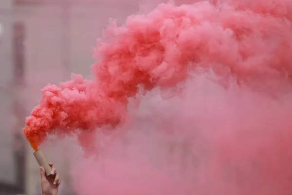 El fişeği kırmızı duman ile tutan bir adam.