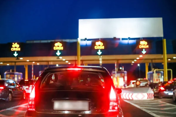 Otoyol otoyol standında nakit işaretleri batımında üzerinde araba bekleyen boş beyaz paneliyle doğrultusunda arkadan görünüş.