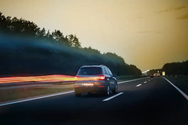 Visão Traseira Carro Dirigindo Estrada Pôr Sol Linhas Luzes Traseiras — Fotografia de Stock