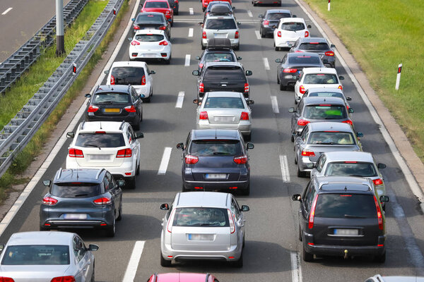 Rear view of traffic jam of lined up cars stuck on the highway toll.