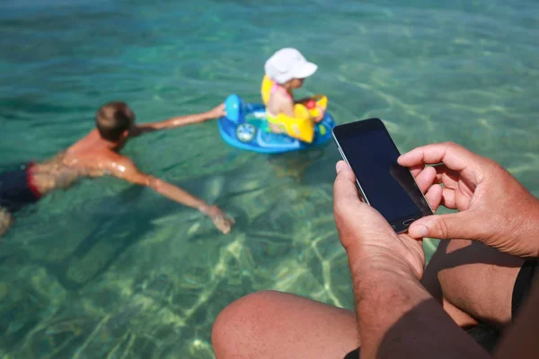 Muž Který Držel Smartphone Při Posezení Molu Moře Podřízenými Nadřazenými — Stock fotografie