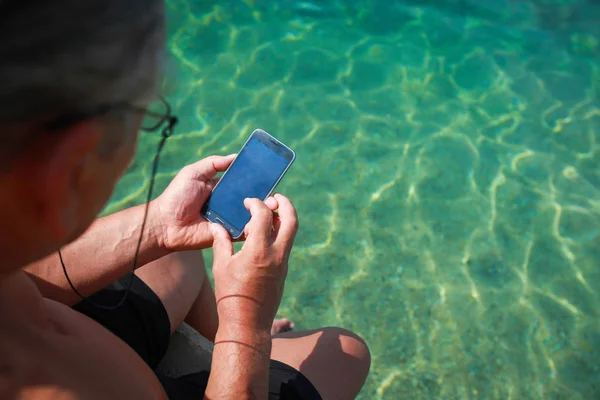 Muž Který Držel Smartphone Při Posezení Molu Moře — Stock fotografie