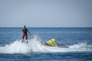 Dugi sıçan, Hırvatistan - 20 Ekim 2018: Bir adam akrobasi Dugi sıçan, Hırvatistan kıyıya yakın jet ski için bağlı flyboard ile yapıyor.