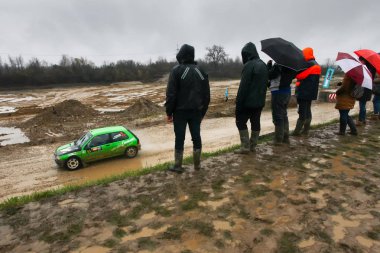 Sveta tepe, Hırvatistan - 25 Kasım 2018. 9 ralli Santa Domenica göster. Seyircilerin yarış Alex Molaro ve Barbara De Renault Clio yarış Vita İtalya'dan çamurlu barajdan izliyor.