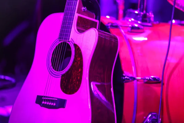 Guitarra con batería bajo luz violeta —  Fotos de Stock