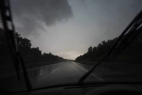 クロアチアのザグレブで黒い雨の嵐の雲と高速道路の交通の車のフロントガラスを通して見る — ストック写真