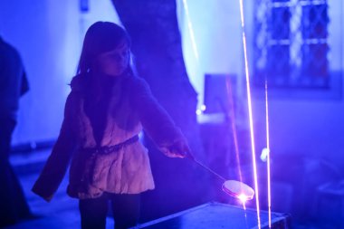 Zagreb, Hırvatistan - 19 Mart 2017: Hırvatistan 'ın Zagreb kentinde ışık festivali. Hırvatistan 'ın Zagreb kentinde lazer ışınlarını keserek oynayan genç bir kız görülüyor.