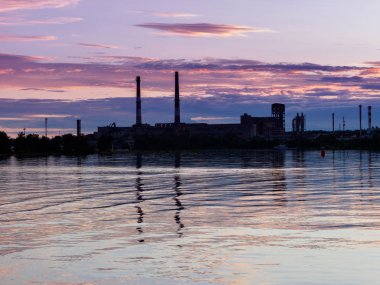 Göl günbatımı. nehir kıyısında fabrika