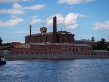 Nehir kıyısında üzerinde kırmızı tuğla fabrikası.