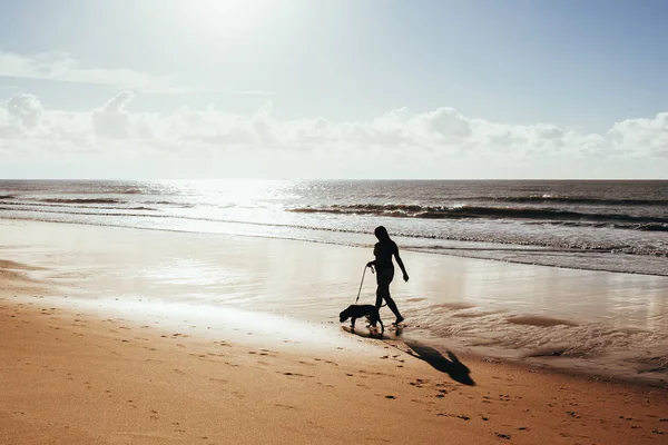 Kobieta Spaceru Psem Plażę Wschodzie Słońca — Zdjęcie stockowe