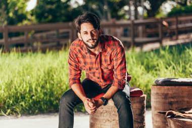 Genç çiftçi mera ve arka planda otlatma atları ile portresi