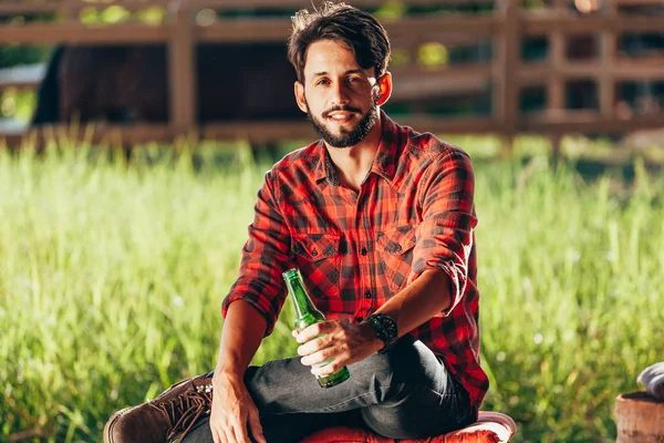 Jonge Boer Zittend Een Bankje Drinken Bier Met Grasland Corral — Stockfoto