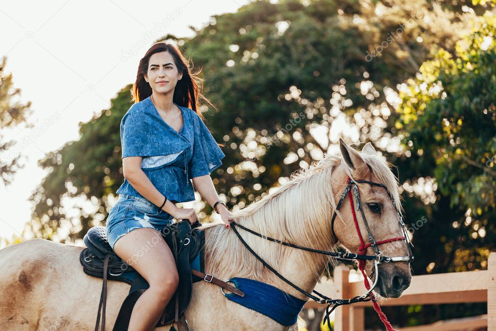 Young woman riding horse on the countryside