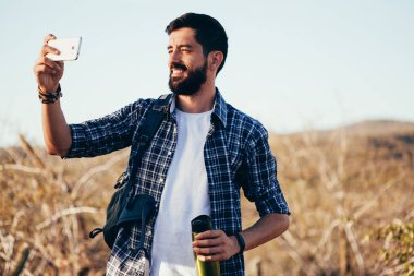 Adam selfie onun cep telefonu ile çöl yürüyüş sırasında alarak sırt çantası ile