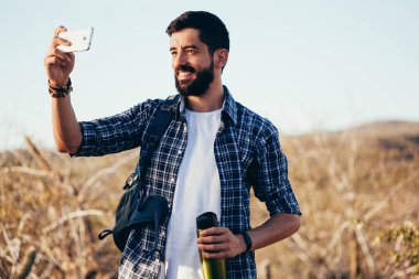 Adam selfie onun cep telefonu ile çöl yürüyüş sırasında alarak sırt çantası ile