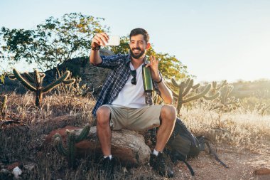 Adam selfie onun cep telefonu ile çöl yürüyüş sırasında alarak sırt çantası ile