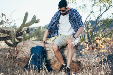 Çölde bir sırt çantası koyarak erkek uzun yürüyüşe çıkan kimse