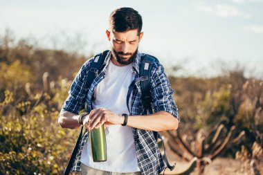 Kol saati çölde seyir yakışıklı bir erkek hiker portresi