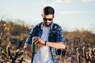 Kol saati çölde seyir yakışıklı bir erkek hiker portresi