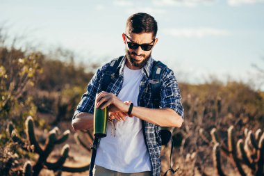 Kol saati çölde seyir yakışıklı bir erkek hiker portresi