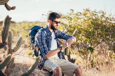 Kol saati çölde seyir yakışıklı bir erkek hiker portresi