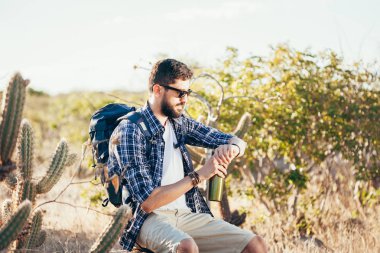 Kol saati çölde seyir yakışıklı bir erkek hiker portresi