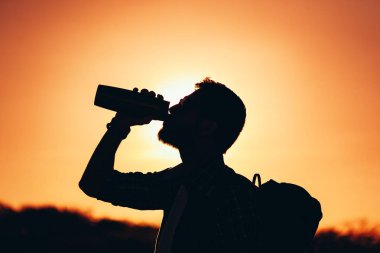 Sırt çantası içme suyu olan adam silüeti