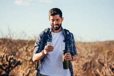 Çölde yürüyüşü sırasında cep telefonuyla uzun yürüyüşe çıkan kimse.