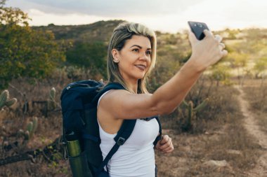 Çöl yürüyüş sırasında selfie ile cep telefonunu alarak sırt çantası kadınla