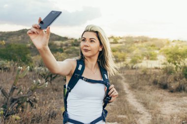 Çöl yürüyüş sırasında selfie ile cep telefonunu alarak sırt çantası kadınla