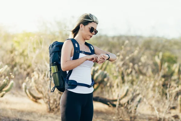 Kol saati çölde bakarak çok kadın bir uzun yürüyüşe çıkan kimse portresi