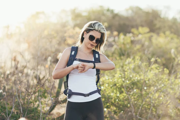 Kol saati çölde bakarak çok kadın bir uzun yürüyüşe çıkan kimse portresi