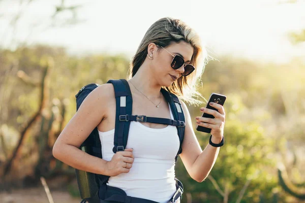 Çölde yürüyüşü sırasında cep telefonuyla uzun yürüyüşe çıkan kimse.