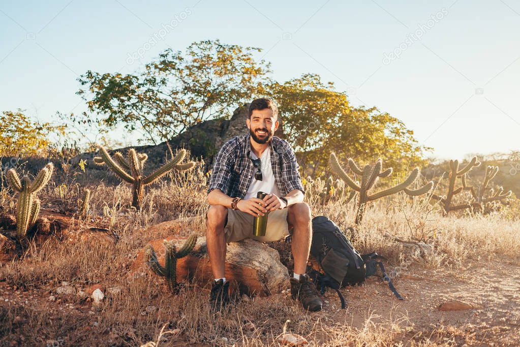 Happy young man hiking with backpack