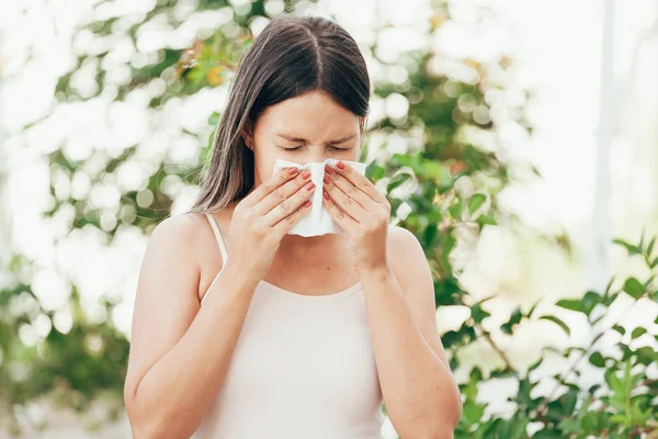 Kvinna med allergisymtom blåser näsa — Stockfoto