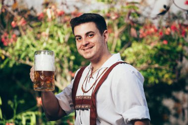 Bira kupa tutan geleneksel Bavyera giysili adam